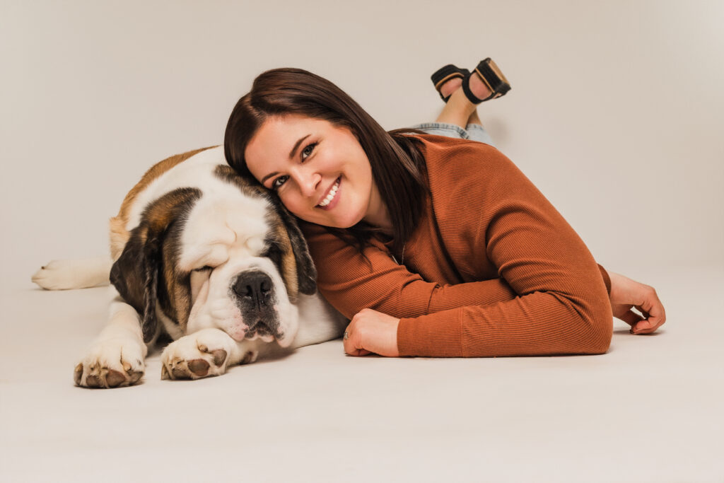 Woman and dog lay on floor for photoshoot 