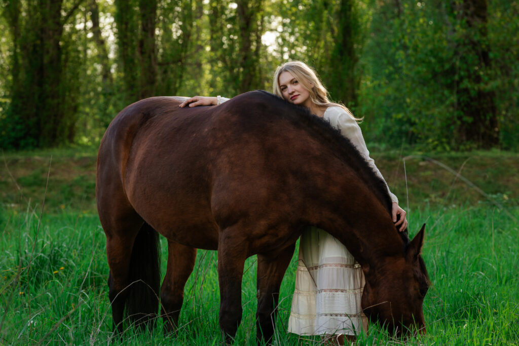 Woman poses with her horse in beautiful white dress